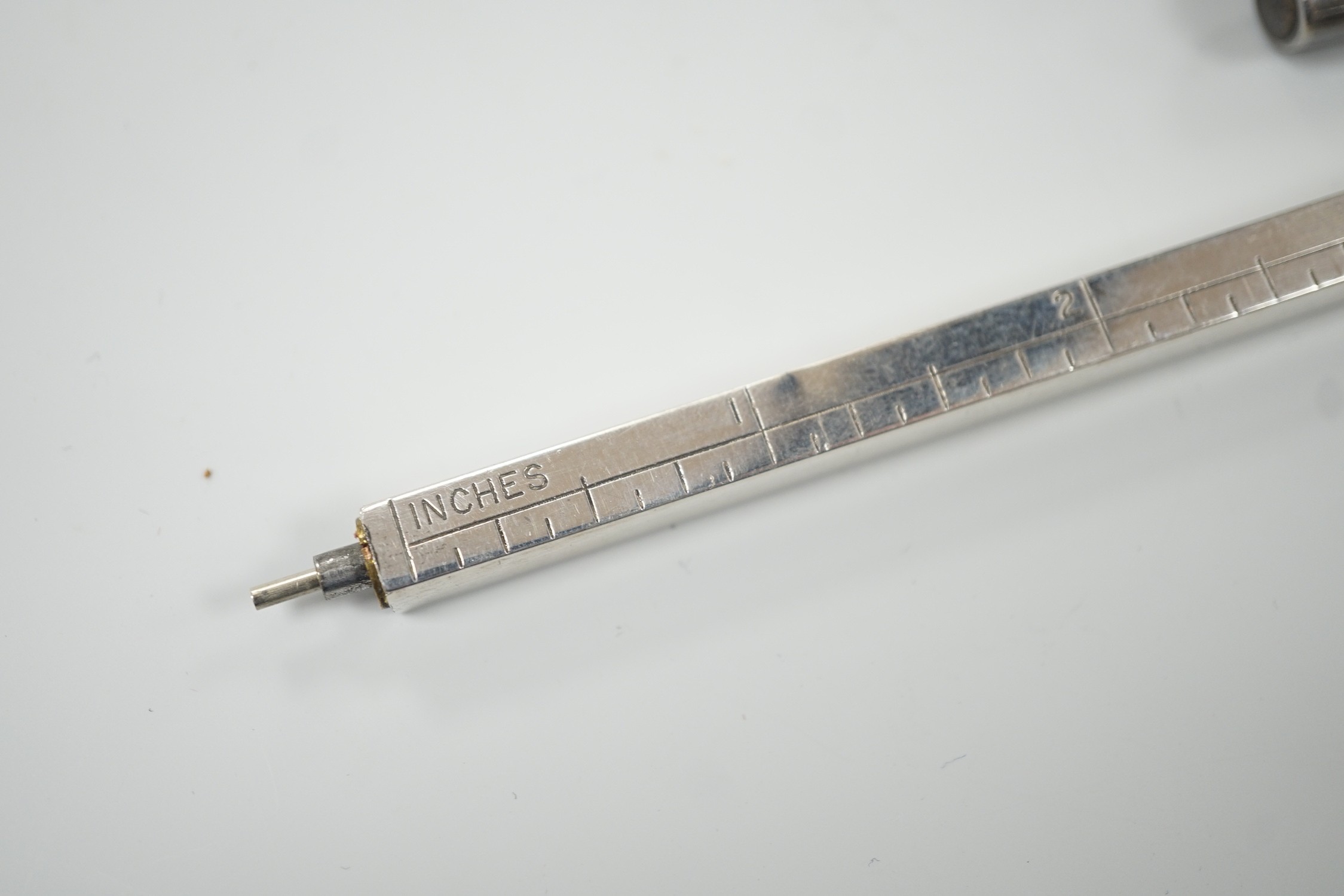 An engine-turned silver fountain pen, a cased set of four silver Bridge pencils and a silver combination pencil/rule